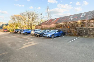 a row of cars parked next to a brick building at The Riverside Rest 2 in Stirling