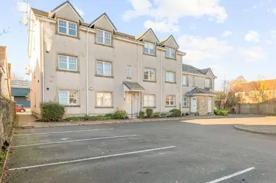 a large apartment building with a parking lot at The Riverside Rest 2 in Stirling