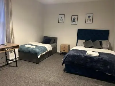 a bedroom with two beds and a dresser and a desk at 23 Ash road in Moffat