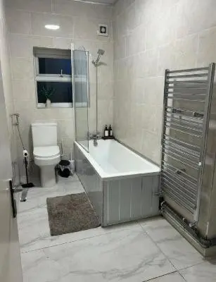 a bathroom with a tub and a toilet and a shower at 23 Ash road in Moffat