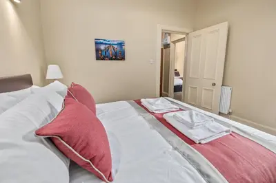 a bedroom with a bed with two towels on it at The Oban Apartment in Oban