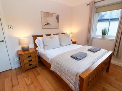 a bedroom with a bed with two towels on it at Cramar Cottage in Glasgow