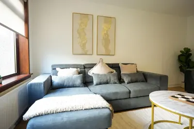 a living room with a blue couch and a table at Nigel House in Livingston
