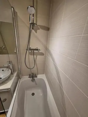 a white bath tub in a bathroom with a sink at Glasgow Southside Apartment in Glasgow