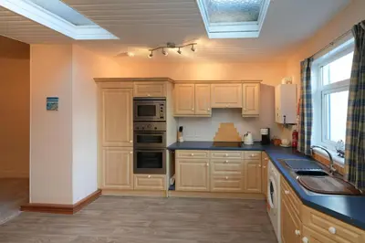 a kitchen with wooden cabinets and a blue counter top at Mariners Haven in Troon in Troon