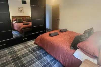 a bedroom with two beds and a large mirror at 3 Bed House - Sea Views Balcony Parking Pets in Innellan