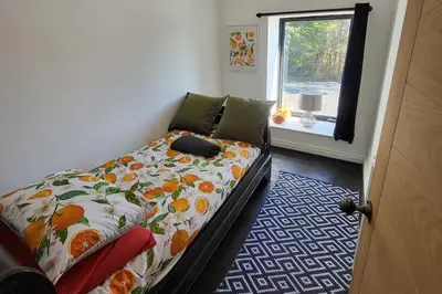 a bedroom with a bed with a comforter and a window at 3 Bed House - Sea Views Balcony Parking Pets in Innellan