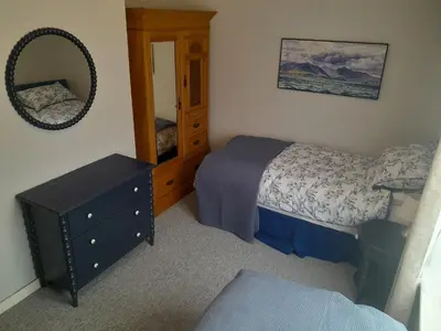 a bedroom with a bed and a dresser and a mirror at 2-Bedroom Flat South Ayrshire in Troon