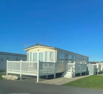 a mobile home with a porch and a white fence at Static Caravan 8 Berth 3 bedrooms, ensuite Saltcoats, Ayrshire, Scotland DG CH in Saltcoats
