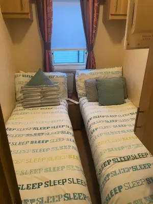 two beds in a small room with a window at Static Caravan 8 Berth 3 bedrooms, ensuite Saltcoats, Ayrshire, Scotland DG CH in Saltcoats