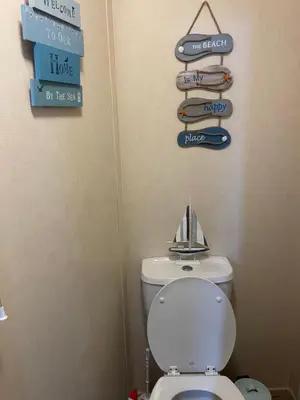 a bathroom with a toilet and signs on the wall at Static Caravan 8 Berth 3 bedrooms, ensuite Saltcoats, Ayrshire, Scotland DG CH in Saltcoats