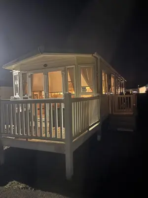 a screened in porch of a house at night at Static Caravan 8 Berth 3 bedrooms, ensuite Saltcoats, Ayrshire, Scotland DG CH in Saltcoats