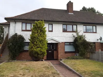 a white house with a tree in the front yard at Carvetii - Jute House, ground floor, 2 bedroom flat in Rosyth