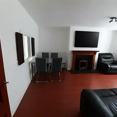 a living room with a table and chairs and a television at Carvetii - Jute House, ground floor, 2 bedroom flat in Rosyth