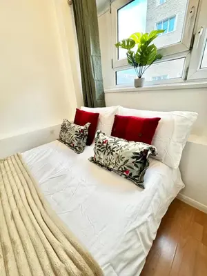 a white bed with pillows in a room with a window at Entire 4 bedrooms Apartment Sleep 8 Central London ZONE1 in Moffat