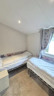 a room with two beds and a window at Caravan Bliss in Minishant