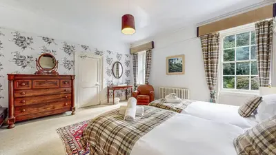 a bedroom with two beds and a dresser at Finest Retreats - Ormidale House in Feorlean