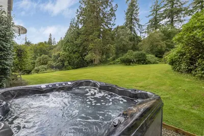 a hot tub in a garden with a grass field at Finest Retreats - Ormidale House in Feorlean