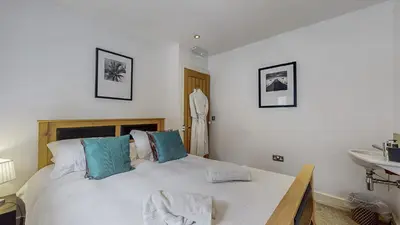 a bedroom with a large bed and a sink at Finest Retreats - Mill House at Ormidale House in Clachan of Glendaruel