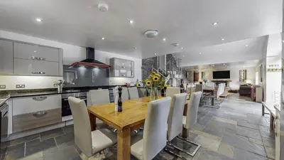 a kitchen and dining room with a wooden table and chairs at Finest Retreats - Mill House at Ormidale House in Clachan of Glendaruel