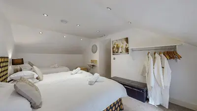 two beds in a bedroom with white walls at Finest Retreats - Mill House at Ormidale House in Clachan of Glendaruel