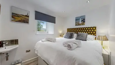 a bedroom with a large white bed and a sink at Finest Retreats - Mill House at Ormidale House in Clachan of Glendaruel