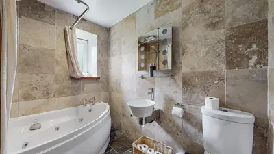a bathroom with a tub and a toilet and a sink at Finest Retreats - Mill House at Ormidale House in Clachan of Glendaruel