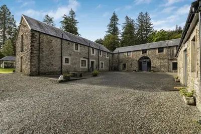an old stone building with a driveway in front at Finest Retreats - Old Barn at Ormidale House in Clachan of Glendaruel