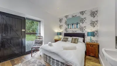 a bedroom with a bed and a tub and a sink at Finest Retreats - Garden Cottage at Ormidale House in Clachan of Glendaruel