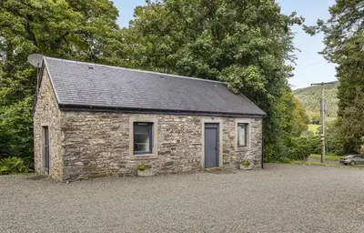 a stone building with a grey roof at Finest Retreats - Garden Cottage at Ormidale House in Clachan of Glendaruel