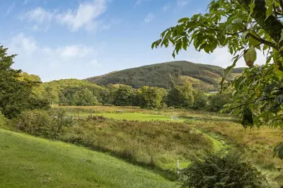 a view of a field with a mountain in the background at Finest Retreats - Garden Cottage at Ormidale House in Clachan of Glendaruel