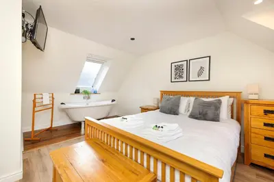 a bedroom with a large bed and a bath tub at JOIVY Lovely Flats in Edinburgh City Centre in Edinburgh