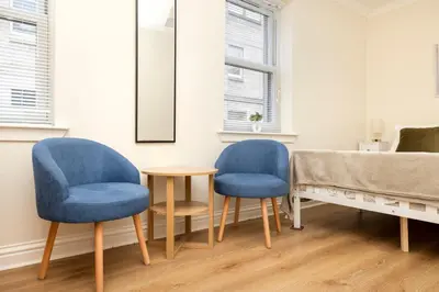 two blue chairs and a table in a room at JOIVY Lovely Flats in Edinburgh City Centre in Edinburgh