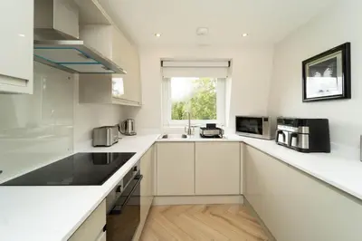 a white kitchen with a sink and a window at Eagleside Apartments in Auchterarder
