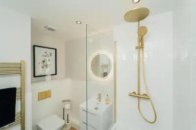 a bathroom with a shower and a toilet and a sink at Eagleside Apartments in Auchterarder