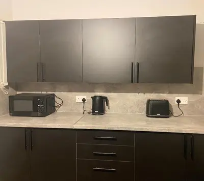 a kitchen counter with a microwave and a toaster oven at 3BR Sleeps 6 Free Parking Near Glasgow City Centre in Renfrew
