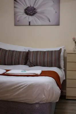 a bedroom with a bed with a flower picture on the wall at 53 Dorset street G3 7AG in Glasgow