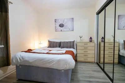 a bedroom with a large bed and a mirror at 53 Dorset street G3 7AG in Glasgow