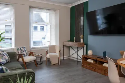 a living room with a large flat screen tv at Vacant Nests Ivy Cottage 3BR Wi-Fi in Kilsyth
