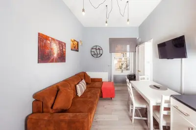 a living room with a brown couch and a table at Central Apartment by the Meadows 9 in Edinburgh