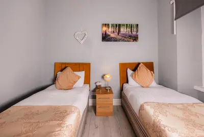 a room with two beds and a picture on the wall at Central Apartment by the Meadows 9 in Edinburgh