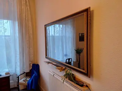 a mirror hanging on a wall next to a window at Heart of West End apartment, Glasgow in Glasgow