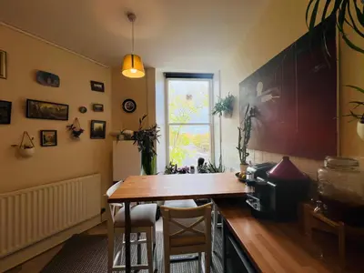 a kitchen with a wooden table and a window at Heart of West End apartment, Glasgow in Glasgow