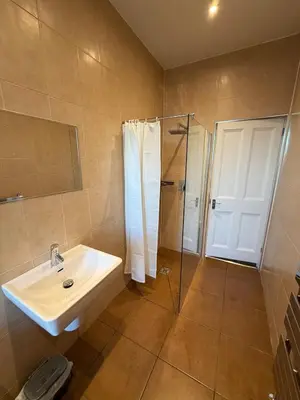 a bathroom with a sink and a shower at Spacious Tenement with free parking in Glasgow