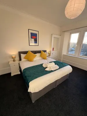 a bedroom with a large bed with yellow pillows at Spacious Tenement with free parking in Glasgow