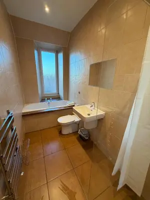 a bathroom with a toilet and a sink and a window at Spacious Tenement with free parking in Glasgow