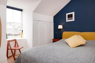a bedroom with a bed and a blue wall at Chic 1-Bedroom Apartment in Edinburgh New Town in Edinburgh