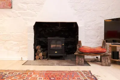 a stone fireplace with a stove in a room at Chic 1-Bedroom Apartment in Edinburgh New Town in Edinburgh