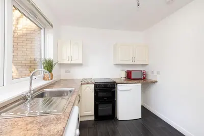 a kitchen with a sink and a counter top at Edinburgh Morningside 2-Bedroom Apartment - Ground Floor in Edinburgh