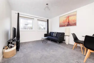 a living room with a couch and a table at Edinburgh Morningside 2-Bedroom Apartment - Ground Floor in Edinburgh